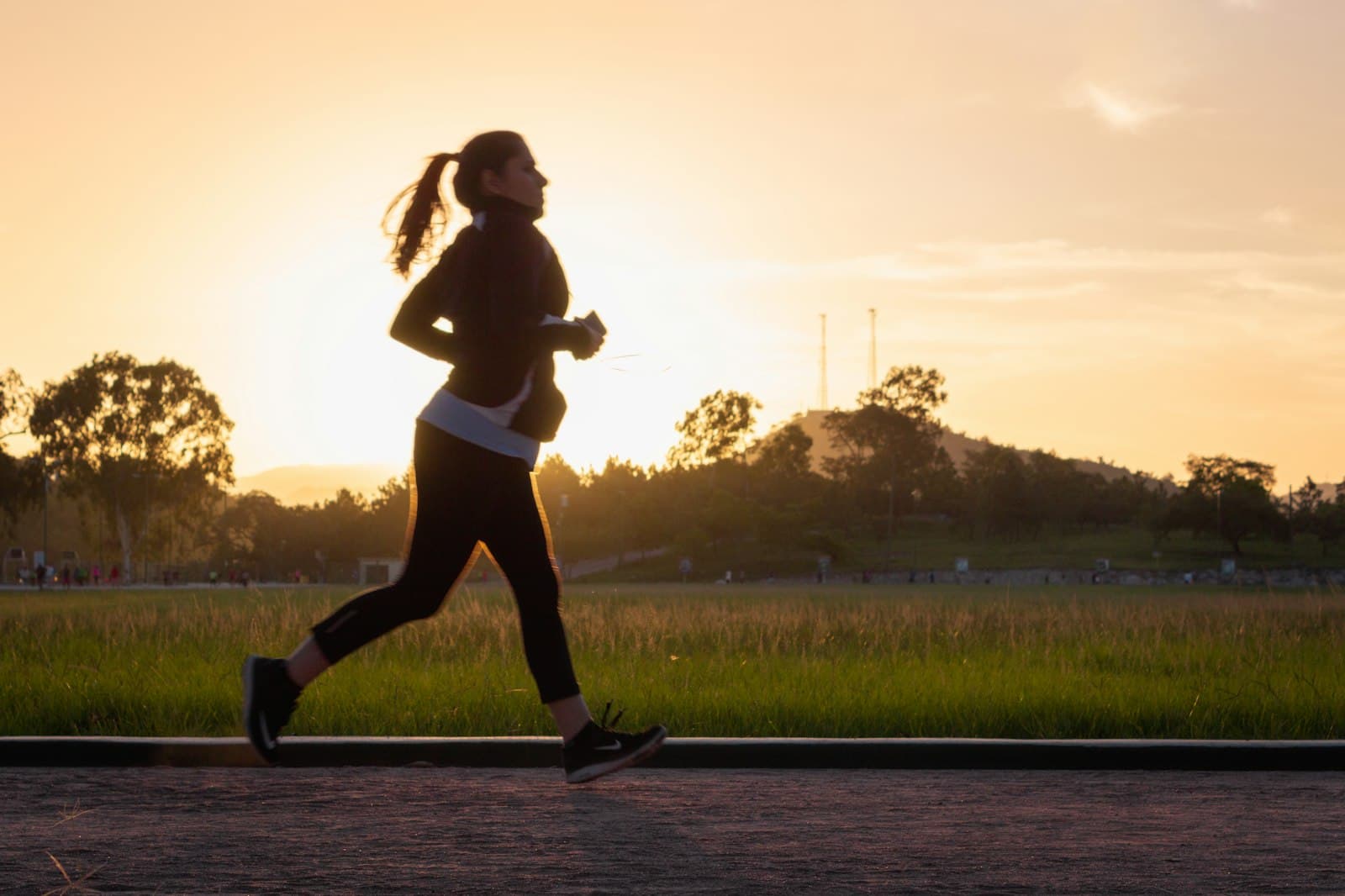 A woman running outdoors at golden hour